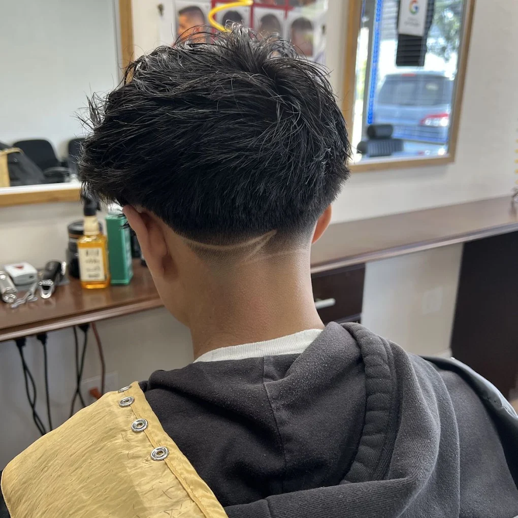 Taper fade with hair design detail on thick dark hair, Kannapolis barbershop